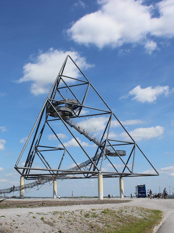 Dreieckige Stahlkonstruktion mit Wendeltreppe vor blauem Himmel. Tetraeder Bottrop, Halde an der Beckstraße, Tour quer durch's Ruhrgebiet