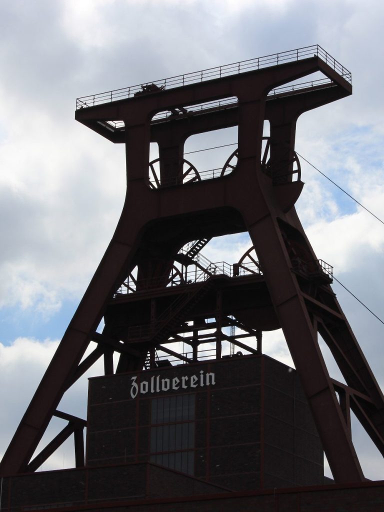 Fördergerüst Zeche Zollverein Schacht 12. Industrieförderturm mit Wolkenhimmel im Hintergrund. Welterbe der UNESCO.